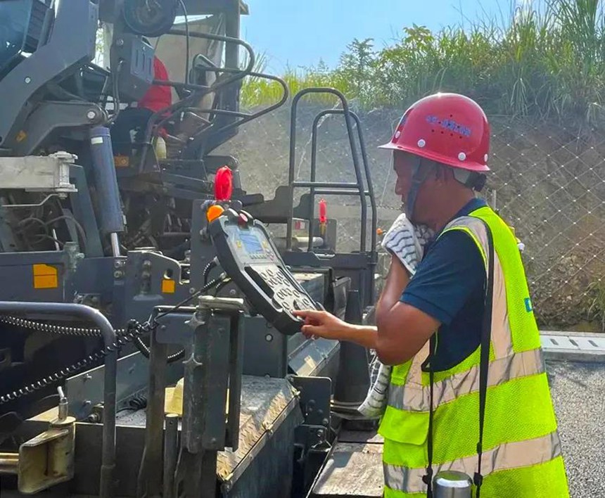 城開高速2021年通車段路面施工現(xiàn)場，瀝青攤鋪工人加緊施工。重慶高速集團供圖