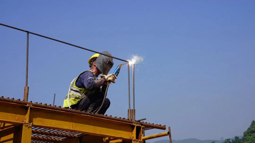 在渝湘復(fù)線永興隧道進口，工人們正在實施高空作業(yè)，緊張忙碌。重慶高速集團供圖