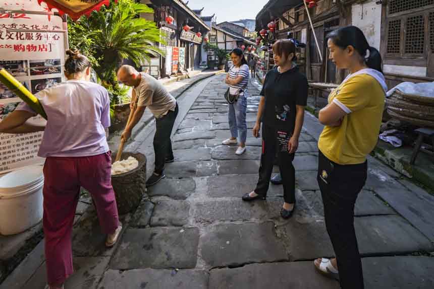 游客感受古鎮(zhèn)傳統(tǒng)民俗——打糍粑。黃進(jìn)攝