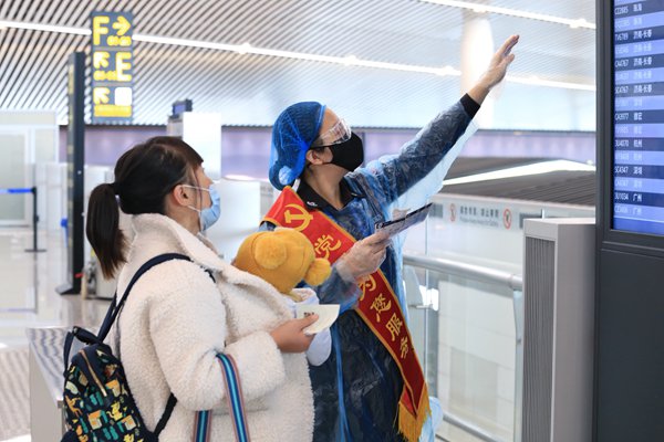 疫情期間，重慶機(jī)場(chǎng)安全檢查站黨員為旅客提供服務(wù)。重慶機(jī)場(chǎng)集團(tuán)供圖