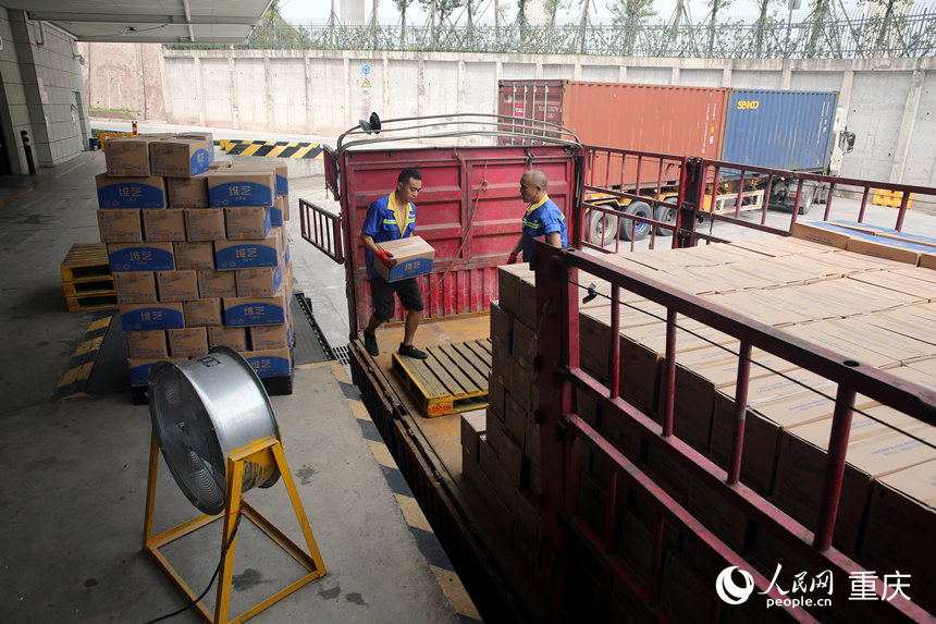 工人們?cè)诿裆C合物流兩江一期基地進(jìn)行散貨出庫(kù)作業(yè)。人民網(wǎng) 劉政寧攝