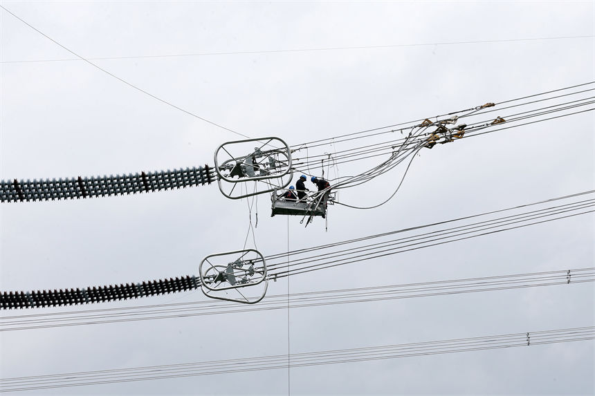 白鶴灘—浙江±800千伏特高壓直流輸電工程重慶黔江分段施工現(xiàn)場(chǎng),工人在高空作業(yè)。 楊敏攝