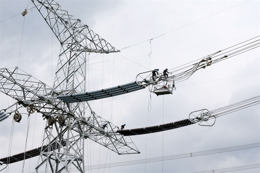 白鶴灘—浙江±800千伏特高壓直流輸電工程重慶黔江分段施工現(xiàn)場(chǎng),工人在高空作業(yè)。 楊敏攝