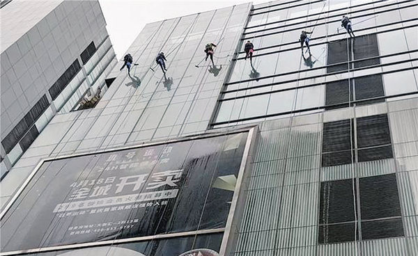 “蜘蛛人”正在從上至下清洗大樓玻璃外墻。