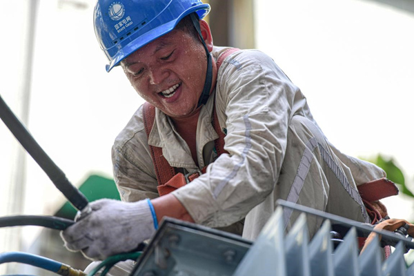 7月13日，國(guó)網(wǎng)合川供電公司員工在10千伏皂蟠線公園路中人2號(hào)臺(tái)區(qū)搶險(xiǎn)配變。秦曉東攝