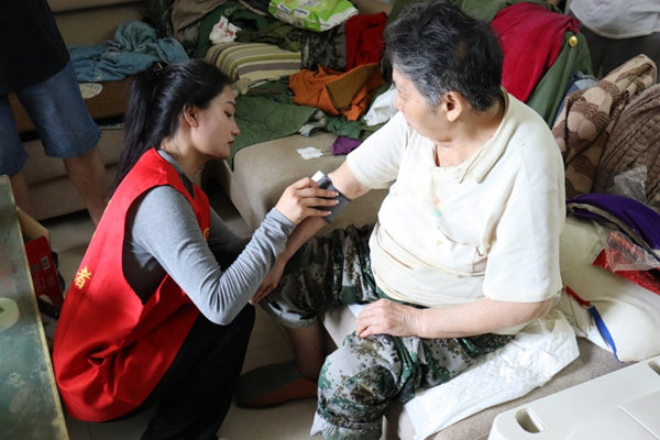 志愿者為老人測量血壓。李雪攝