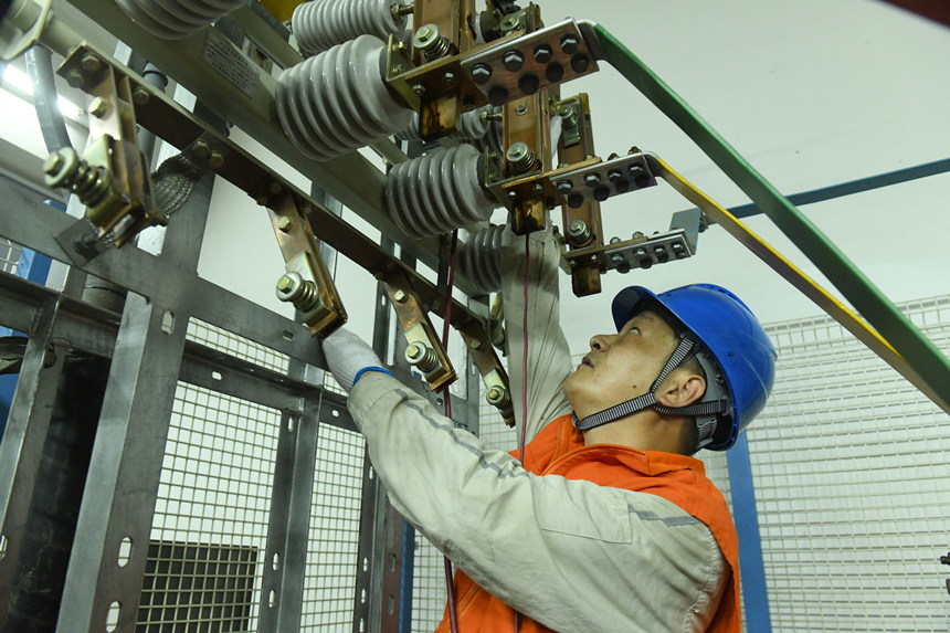 8月10日晚，國家電網(wǎng)紅巖（璧山運檢）共產(chǎn)黨員服務(wù)隊隊員在110千伏大路變電站檢修3號電容器。周毅攝