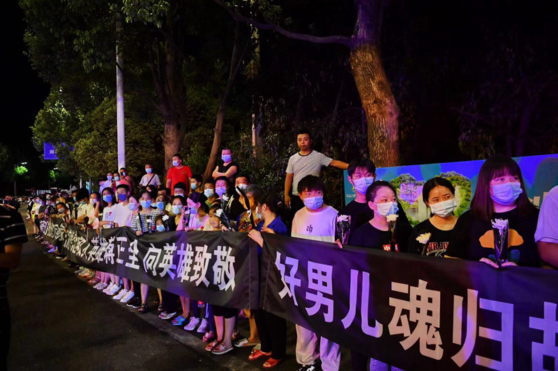 當?shù)厝罕娮园l(fā)迎接英雄回家。賀奎攝