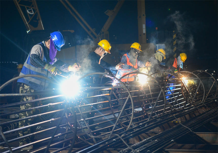 工作人員正在進(jìn)行夜間鋼筋電焊作業(yè)。郭旭攝