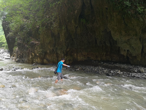 《過河》。6月30日，在巫山縣竹賢鄉(xiāng)下莊村谷底峽谷，川東南地質(zhì)大隊(duì)地災(zāi)駐守隊(duì)員龔強(qiáng)蹚水過河到對(duì)面的地質(zhì)災(zāi)害點(diǎn)進(jìn)行調(diào)查。易洪志攝