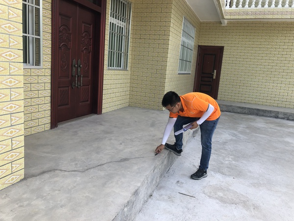 《清晨的野外巡查》。7月9日早上8時,黔江區(qū)駐守地質(zhì)隊員潘笑天在五里鎮(zhèn)嚴(yán)家河進(jìn)行巡查，現(xiàn)場調(diào)查記錄滑坡體上房屋的變形情況。  曹志遠(yuǎn)攝