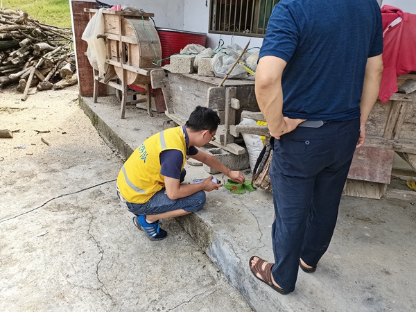 《簡易監(jiān)測，就地取材》。7月5日，黔江區(qū)水市鎮(zhèn)楊柳村地災(zāi)隱患點，107地質(zhì)隊駐守地質(zhì)隊員諶立志正在進(jìn)行日常巡查。在缺乏專業(yè)工具的情況下，他就地取材利用“樹葉掏洞”的小方法現(xiàn)場設(shè)立簡易監(jiān)測點，指導(dǎo)監(jiān)測人員開展地災(zāi)監(jiān)測。路正昆攝