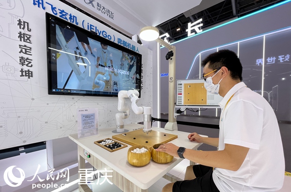 2022智博會(huì)科大訊飛展臺(tái)的工作人員演示與弈棋機(jī)器人對(duì)弈。人民網(wǎng) 胡虹攝
