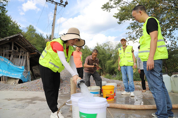 秀山縣應(yīng)急管理局黨員先鋒突擊隊(duì)隊(duì)員正在為村民接水。任燕攝