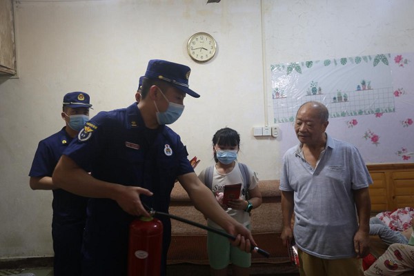 消防宣傳員為居民示范滅火器的使用方法。渝中區(qū)消防救援支隊(duì)供圖