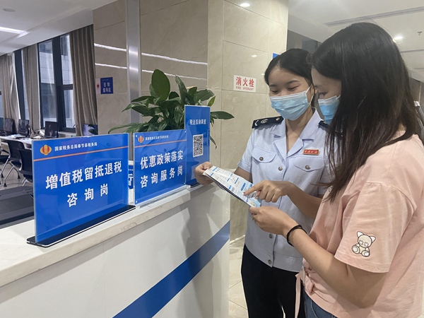 奉節(jié)縣稅務(wù)人員向納稅人介紹新的組合式稅費支持政策。雷睿攝