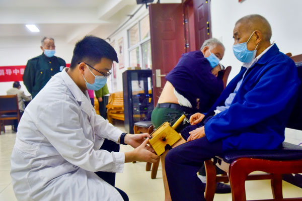 為老人進行艾灸治療。陶涵攝