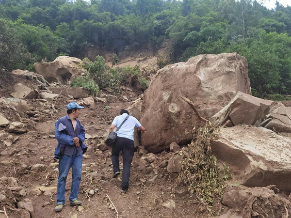 《應(yīng)急調(diào)查黃柏鄉(xiāng)黃嶺樹危巖》。2021年5月25日，南江地質(zhì)隊駐守隊員程?。ㄓ遥y帶無人機(jī)對黃柏鄉(xiāng)黃嶺樹危巖進(jìn)行應(yīng)急調(diào)查，右側(cè)的孤石（直徑約3m）為調(diào)查前幾日危巖崩塌形成，距離下部房屋僅10m。劉偉攝