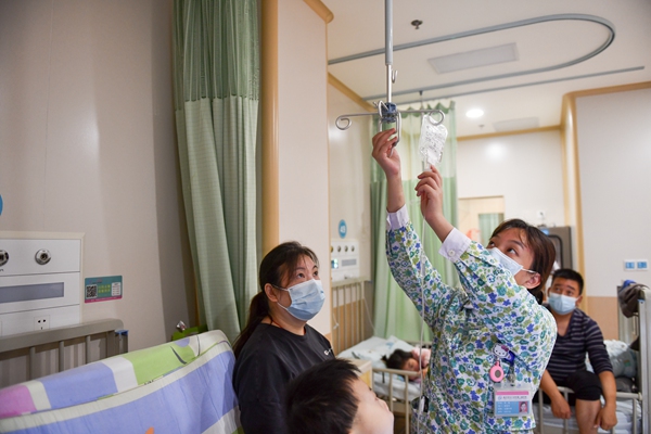 感染科護(hù)士（中）為患者進(jìn)行日常治療。鄒樂攝