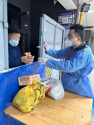 九龍坡區(qū)稅務(wù)局青年黨員志愿者黎禹希（右）把買到的藥交給袁老。重慶市稅務(wù)局供圖