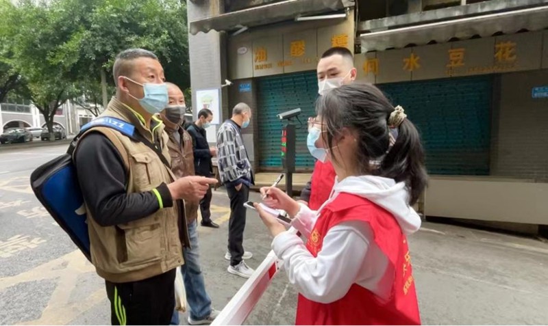 “00后”志愿者秦榕浚一一記下附近居民所需的蔬菜。蔣歡攝