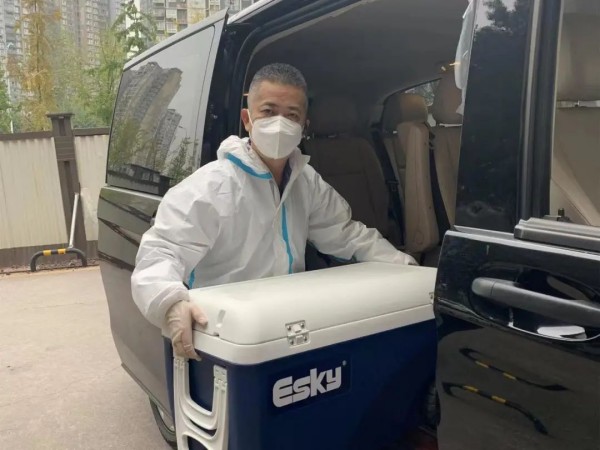 盧行正在往車上搬運物資。