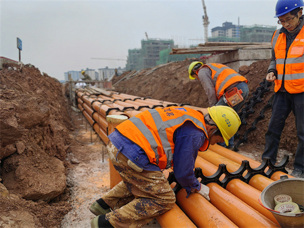 工人們正在進(jìn)行地下電力管網(wǎng)安裝及回填施工。中建七局西南公司供圖