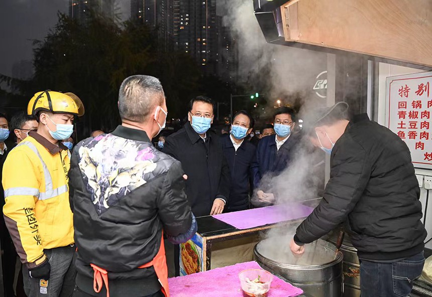 12月12日下午，在解放碑中央商務(wù)區(qū)，市委書記袁家軍同面館老板交流。記者 蘇思 攝/視覺重慶