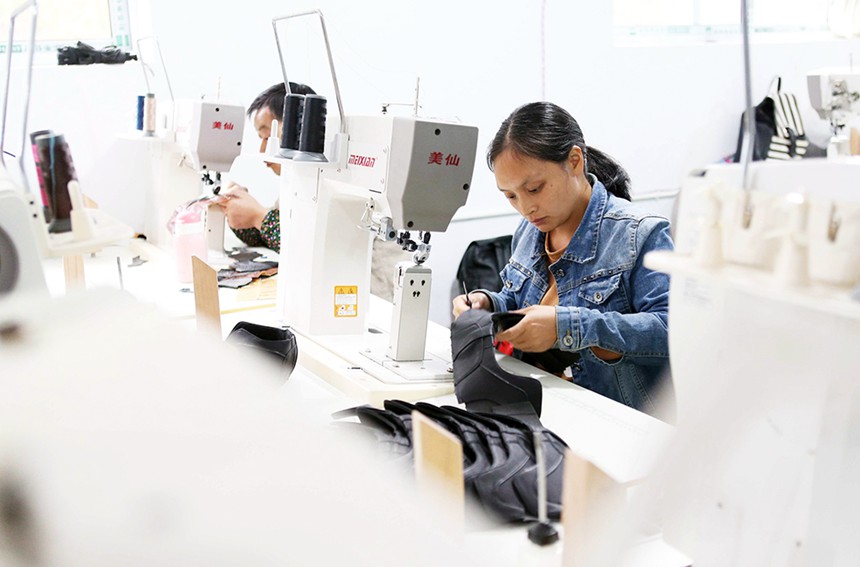 10月27日，女工在黔江區(qū)黃溪鎮(zhèn)親親制鞋廠縫制鞋幫。該鞋廠招收的50多名村民全部通過技能培訓(xùn)，加工的鞋產(chǎn)品均為海外訂單。特約攝影 楊敏/視覺重慶