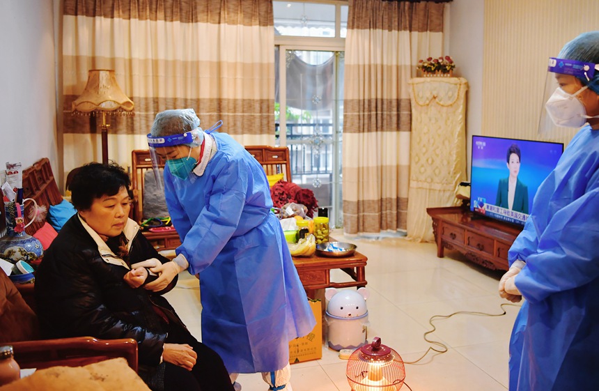 社區(qū)工作人員和醫(yī)護(hù)人員來(lái)到蔣德瓊家中為她接種新冠疫苗。周舸攝