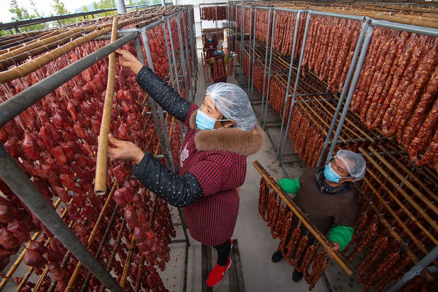 村民在寒冷中晾曬臘腸。?冉孟軍攝