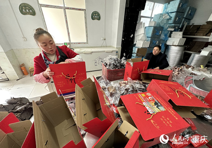 張永紅坐著輪椅在打包車間提醒注意事項(xiàng)。人民網(wǎng) 劉政寧攝