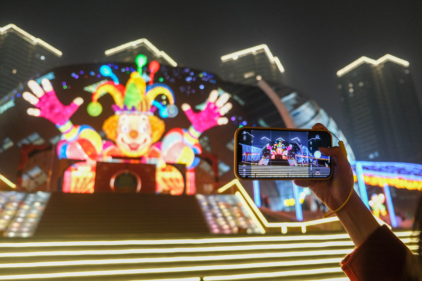 觀眾在燈飾《快樂騎士》留影。郭旭攝