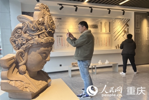 采訪團(tuán)記者拍攝石雕作品。人民網(wǎng) 胡虹攝