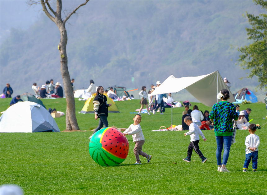 小朋友在草坪上嬉戲玩耍。郭旭攝