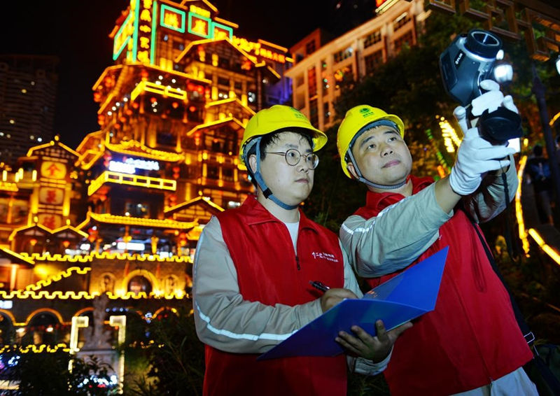 4月30日，國家電網(wǎng)紅巖（市區(qū)渝中）共產(chǎn)黨員服務(wù)隊(duì)在洪崖洞景區(qū)開展巡視，守護(hù)山城璀璨夜。韓薇攝