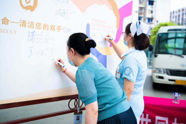 居民與醫(yī)務(wù)人員共同在承諾墻上簽下自己的名字。重慶醫(yī)藥高專附一院供圖