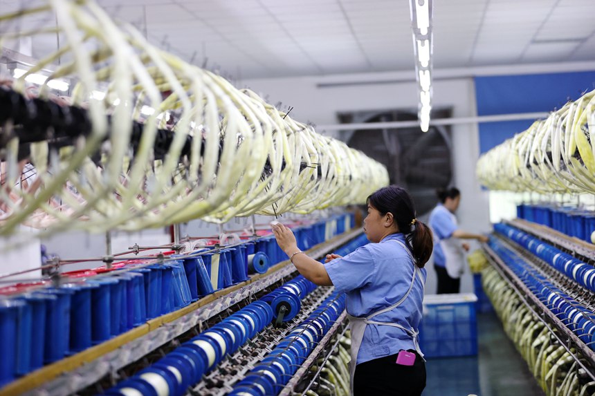 絲綢紡織女工在生產(chǎn)車間忙碌。楊敏攝
