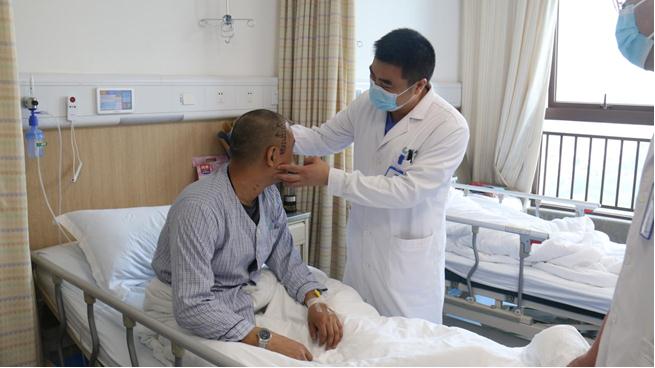 梁鴻查看病人情況。重慶西區(qū)醫(yī)院供圖