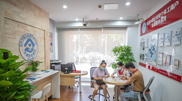重慶農(nóng)商行南岸彈子石支行金融服務(wù)港灣的工作人員為前來咨詢的商戶介紹普惠金融貸款相關(guān)政策和產(chǎn)品。重慶農(nóng)商行供圖