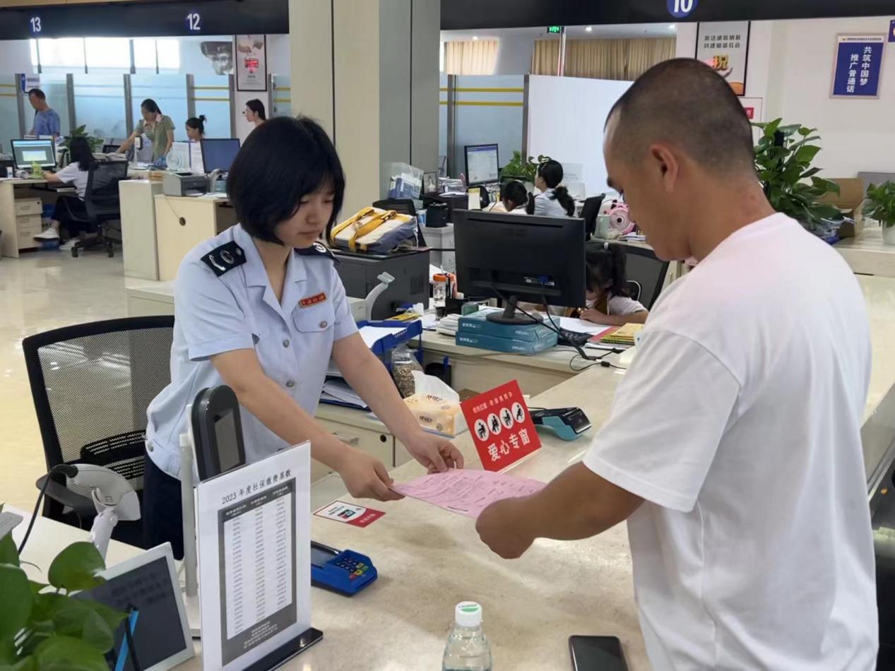 在大足區(qū)辦稅服務(wù)廳，愛心專窗稅務(wù)人員正在為殘疾人士辦理涉稅業(yè)務(wù)。蔣寧澤攝