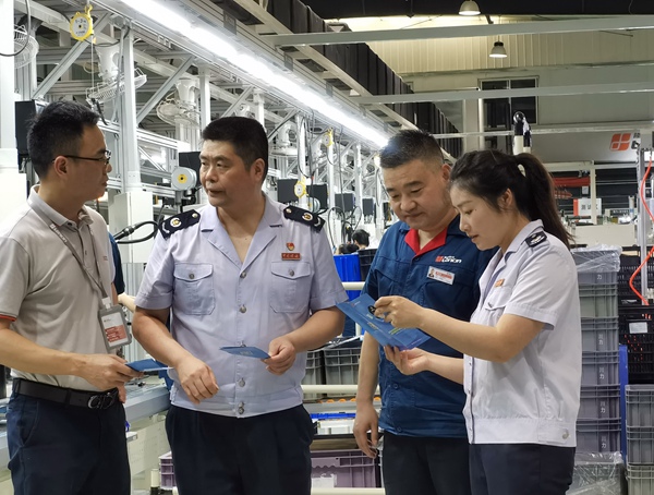 在重慶隆鑫發(fā)動(dòng)機(jī)有限公司，高新區(qū)稅務(wù)局人員宣傳輔導(dǎo)研發(fā)費(fèi)用加計(jì)扣除等稅收優(yōu)惠政策。王玉婷攝