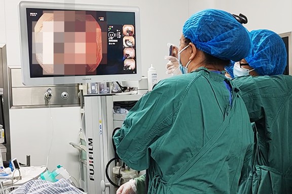 內(nèi)鏡團(tuán)隊(duì)為患者取啤酒瓶蓋。重慶西區(qū)醫(yī)院供圖