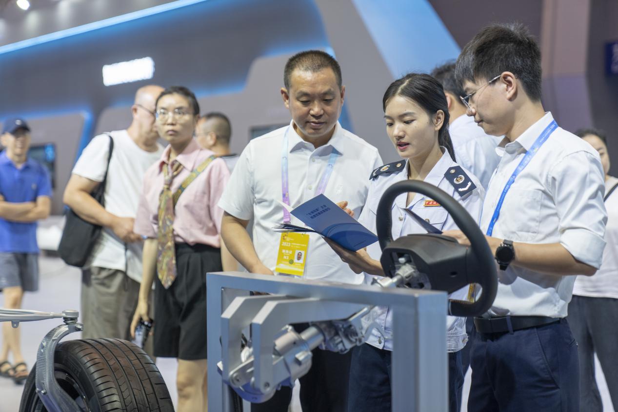 智博會現(xiàn)場，在重慶龍潤汽車轉向器有限公司展區(qū)，璧山區(qū)稅務人員正宣傳研發(fā)費用加計扣除等稅收優(yōu)惠政策。郭睿攝