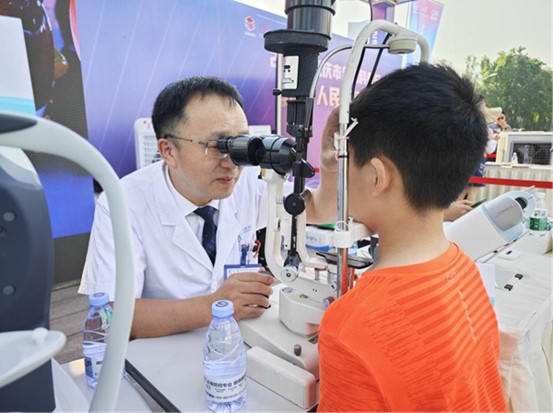 周自強為現(xiàn)場市民義診。重慶愛爾眼科醫(yī)院總院供圖