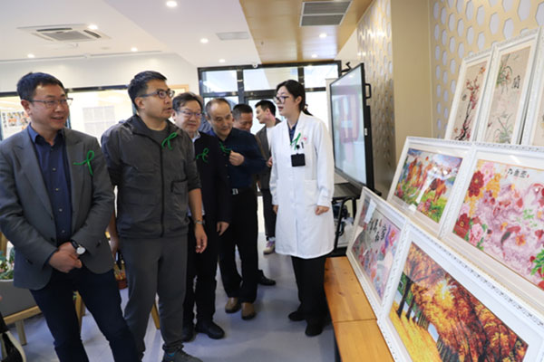 重慶市精神衛(wèi)生中心康復(fù)科主任袁媛向參觀者介紹患者作品。重慶市精神衛(wèi)生中心供圖