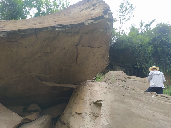 《渺小，但不膽小》。9月3日，在云陽(yáng)縣普安鄉(xiāng)姚平村，107地質(zhì)隊(duì)駐守地質(zhì)工程師姜雙桃在長(zhǎng)江支流磨刀溪兩岸的陡壁上詳實(shí)記錄危巖情況。李明亮攝