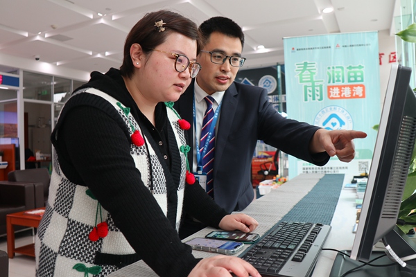 在三峽銀行綦江支行銀行，工作人員輔導市民韓女士網(wǎng)上申報納稅。李奕萱攝