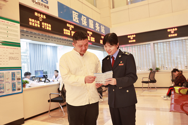 在重慶市第九人民醫(yī)院“醫(yī)保服務(wù)站”，稅務(wù)人員正向繳費(fèi)人宣傳講解醫(yī)保繳費(fèi)政策。楊蔓攝