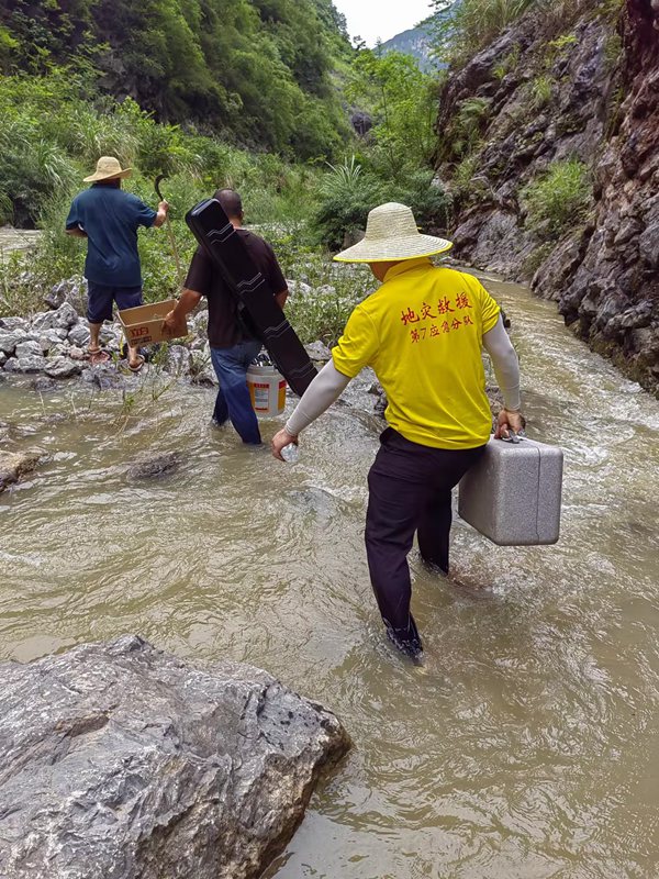 《跋山涉水  調(diào)查險(xiǎn)情》。7月上旬，重慶地質(zhì)礦產(chǎn)研究院駐守地質(zhì)工程師葉兆榮（右），攜帶地質(zhì)調(diào)查航拍設(shè)備，前往巫山縣兩坪鄉(xiāng)開展三峽庫區(qū)重大危巖崩塌隱患調(diào)查。鄧朝松攝